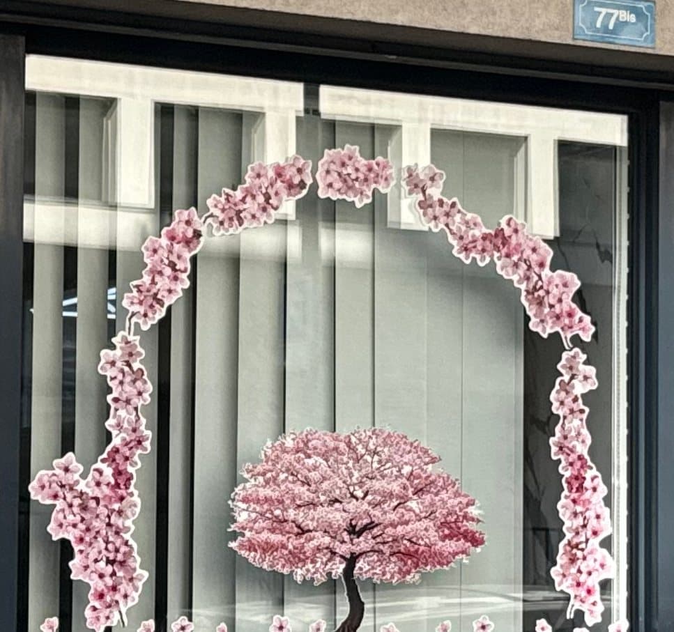 Détail de la vitrine : une arche de fleurs de cerisier autour d'un arbre rose