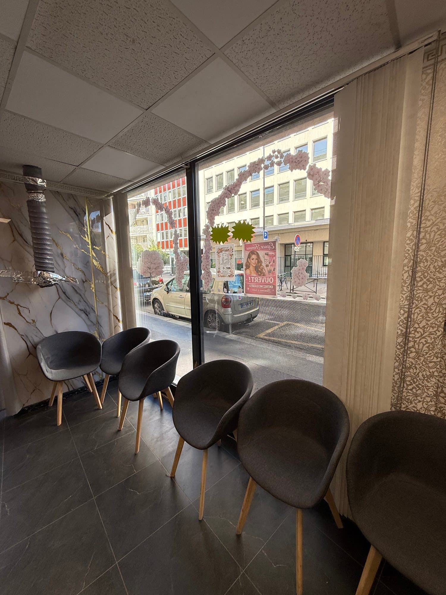 Espace Femme : fauteuils d'attente gris alignés le long de la vitrine